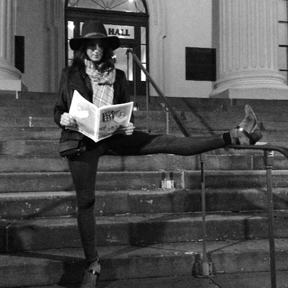 Mary John reading the newspaper in front of city hall